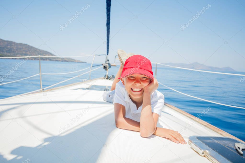 Little boy having fun on yacht on summer cruise. Travel adventure, yachting with child on family vacation.