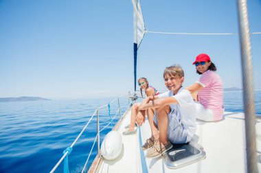 Annesi ve kız kardeşi yatta dinlenen mutlu çocuk