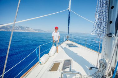 Küçük çocuk yaz gezisinde yelkenli yatında. Seyahat macerası, çocuğuyla yat gezisi..