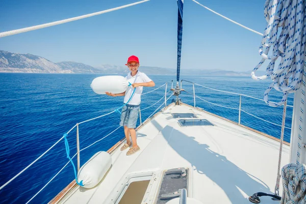 Menino a bordo do iate à vela no cruzeiro de verão. Viagem aventura, iatismo com criança em férias em família. — Fotografia de Stock