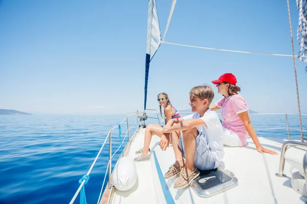 Ragazzo con la sorella e la madre a bordo di yacht a vela in crociera estiva . — Foto Stock