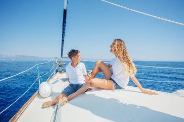 Oğlan ve kız kardeşi yaz gezisinde yelkenli teknesinde..