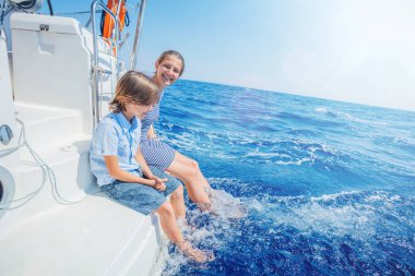 Oğlan ve kız kardeşi yaz gezisinde yelkenli teknesinde..