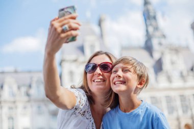 Mutlu anne ve oğlu Paris'teki Hotel de Ville yakınlarında selfie çekiyorlar. Fransa'da tatilintadını çıkaran turistler.