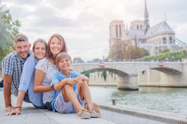 Mutlu aile Paris 'teki Notre-Dame katedrali yakınlarında eğleniyor. Turistler Fransa 'da tatillerinin tadını çıkarıyorlar.