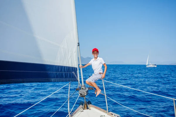 Niño a bordo de un yate de vela en un crucero de verano. Aventura de viaje, yates con niños en vacaciones en familia. — Foto de Stock