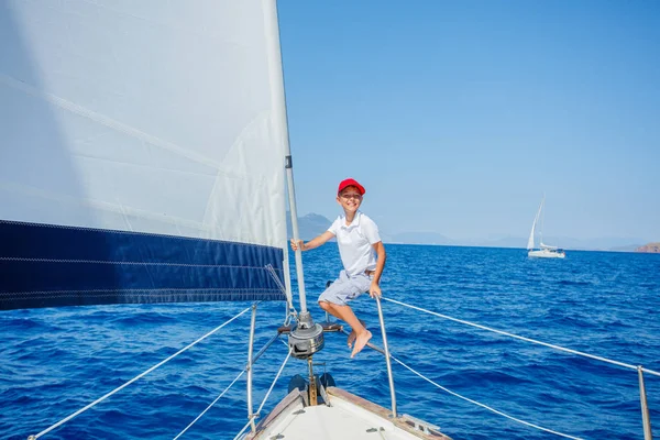 Niño a bordo de un yate de vela en un crucero de verano. Aventura de viaje, yates con niños en vacaciones en familia. — Foto de Stock