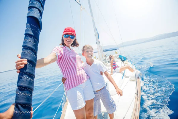 Ragazzo con la sorella e la madre a bordo di yacht a vela in crociera estiva . — Foto Stock