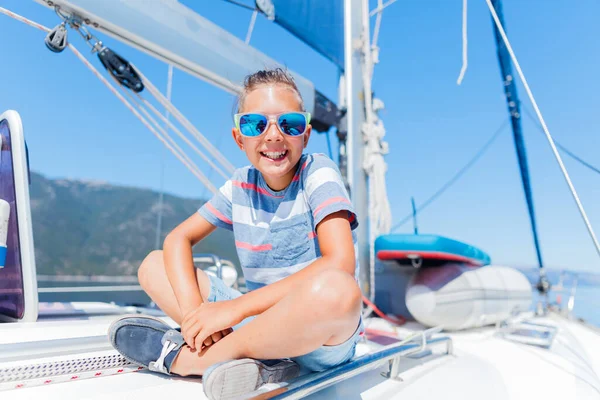 Niño a bordo de un yate de vela en un crucero de verano. Aventura de viaje, yates con niños en vacaciones en familia. — Foto de Stock