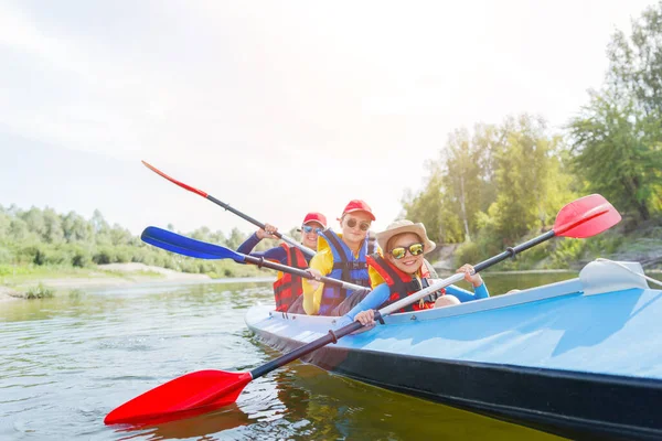 Glad pojke kajak på floden på en solig dag under sommarlovet — Stockfoto