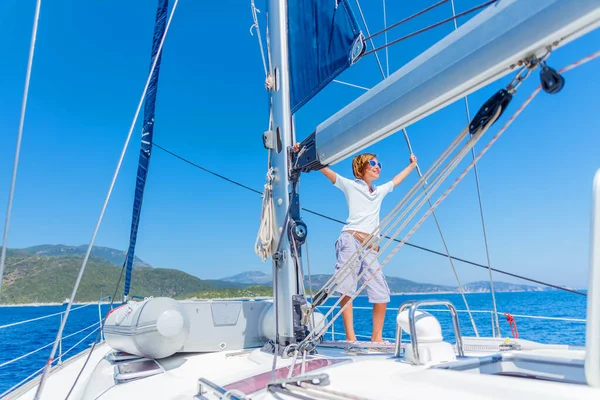 Menino a bordo do iate à vela no cruzeiro de verão. Viagem aventura, iatismo com criança em férias em família. — Fotografia de Stock