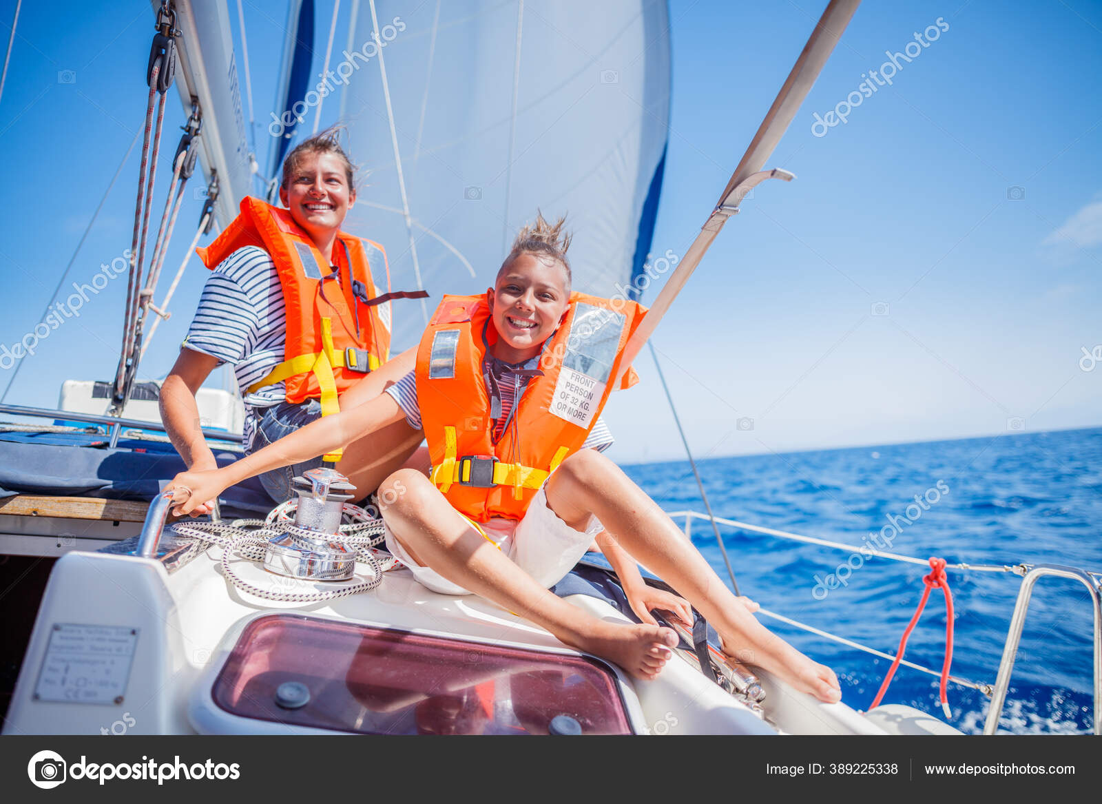 Garçon avec sa sœur à bord d'un voilier en croisière d'été