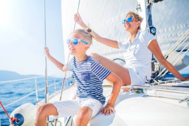 Oğlan ve kız kardeşi yaz gezisinde yelkenli teknesinde..