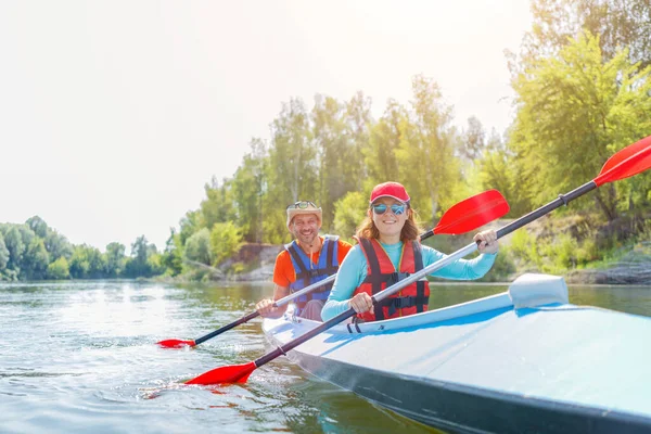 Glückliche Familien-Kajakfahren auf dem Fluss an einem sonnigen Tag im Sommerurlaub — Stockfoto