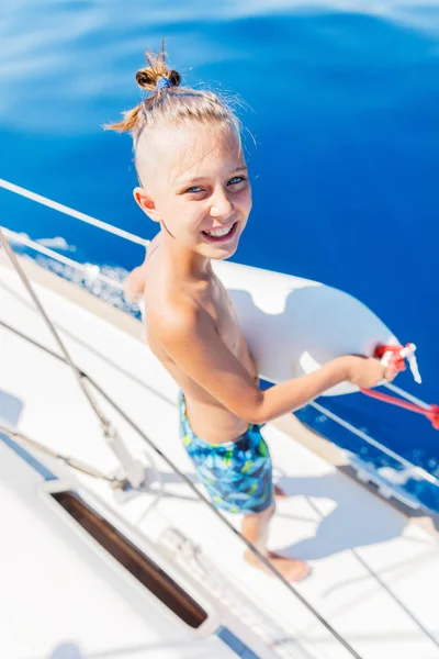 Niño a bordo de un yate de vela en un crucero de verano. Aventura de viaje, yates con niños en vacaciones en familia. — Foto de Stock