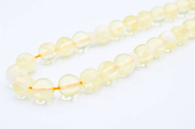 Beyaz boncuklar sıralı, kısa tespih tesbih, Türk kültürü için önemli bir aksesuar, beyaz arka planda izole edilmiş.