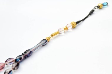 Renkli ve altın boncuklar sıralı, kısa tespih tesbih, Türk kültürü için önemli bir aksesuar, beyaz arka planda izole edilmiş.