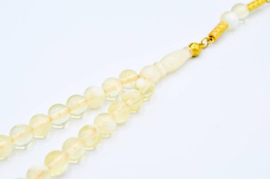 Beyaz ve altın boncuklar sıralı, kısa tespih tesbih, Türk kültürü için önemli bir aksesuar, beyaz arka planda izole edilmiş.