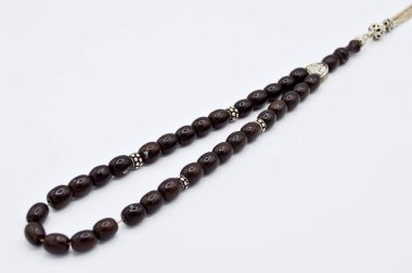 Siyah ve gümüş boncuklar sıralı, kısa tespih tesbih, Türk kültürü için önemli bir aksesuar, beyaz arka planda izole edilmiş.