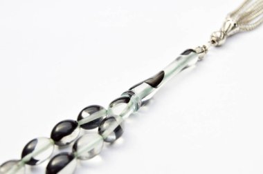 Siyah beyaz ve gümüş boncuklar sıralı, kısa tespih tesbih, Türk kültürü için önemli bir aksesuar, beyaz arka planda izole edilmiş.