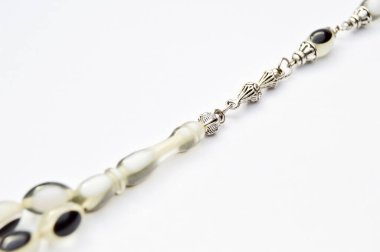 Siyah beyaz ve gümüş boncuklar sıralı, kısa tespih tesbih, Türk kültürü için önemli bir aksesuar, beyaz arka planda izole edilmiş.