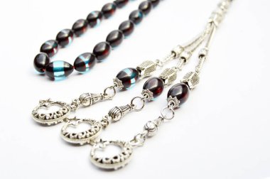 Siyah mavi ve gümüş boncuklar sıralı, kısa tespih tesbih, Türk kültürü için önemli bir aksesuar, beyaz arka planda izole edilmiş.