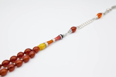 Turuncu ve gümüş boncuklar sıralı, kısa tespih tesbih, Türk kültürü için önemli bir aksesuar, beyaz arka planda izole edilmiş.