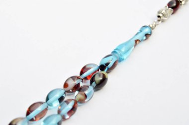 Renkli ve gümüş boncuklar sıralı, kısa tespih tesbih, Türk kültürü için önemli bir aksesuar, beyaz arka planda izole edilmiş.