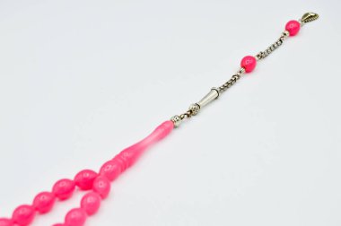 Pembe ve gümüş boncuklar sıralanmış, kısa tespih lekesi, Türk kültürü için önemli bir aksesuar, beyaz arka planda izole edilmiş.