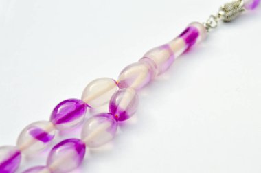 Mor ve gümüş boncuklar sıralı, kısa tespih tesbih, Türk kültürü için önemli bir aksesuar, beyaz arka planda izole edilmiş.