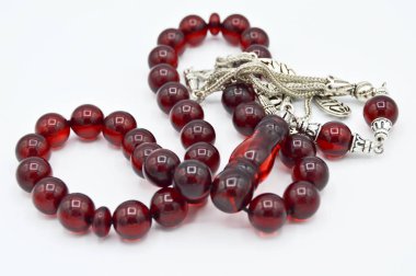 Kırmızı ve gümüş boncuklar sıralı, kısa tespih tesbih, Türk kültürü için önemli bir aksesuar, beyaz arka planda izole edilmiş.