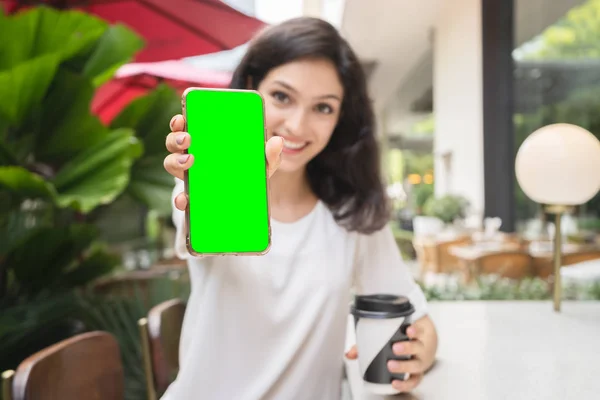 Jovem mulher mostrando smartphone ouro moderno com tela verde para substituição — Fotografia de Stock