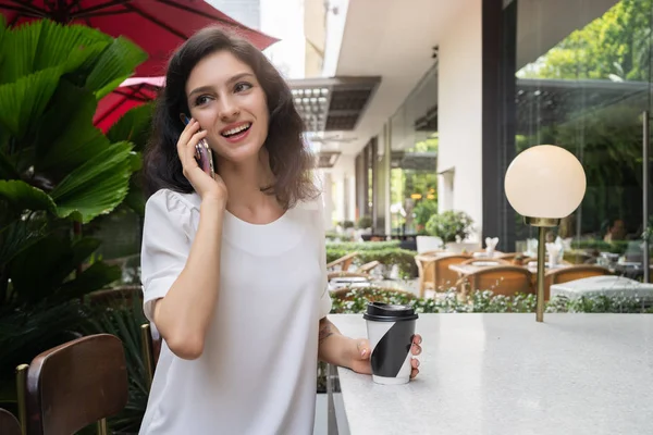 Mulher encantadora com sorriso falando por telefone celular durante o descanso no café — Fotografia de Stock