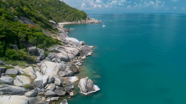 Sobrevolando la increíble playa rocosa y laguna tropical con yate — Vídeo de stock