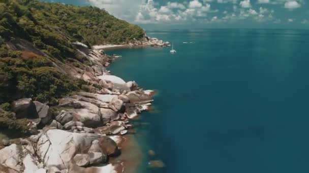 Sobrevolando la increíble playa rocosa y laguna tropical con yate — Vídeo de stock