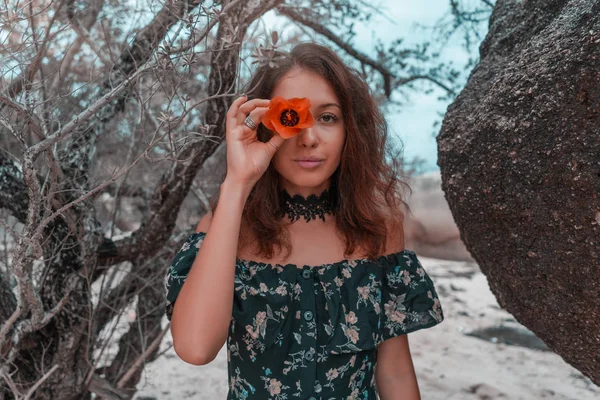 Young woman holding orange flower on her eye — Stock Photo, Image