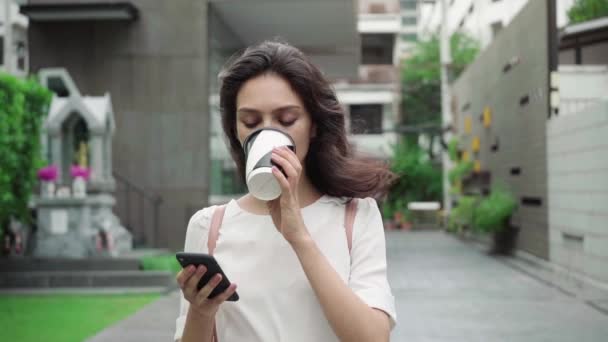 Tjej går på stadens gator och dricka kaffe att gå i super slow motion — Stockvideo