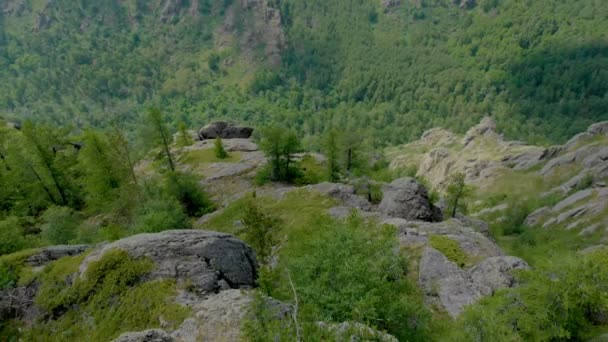 Veduta aerea, drone Vola sopra la ragazza seduta su una parete rocciosa — Video Stock