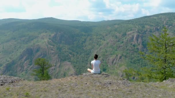 Drone Volar sobre impresionantes montañas con chica en una cara de acantilado, efecto vértigo — Vídeo de stock