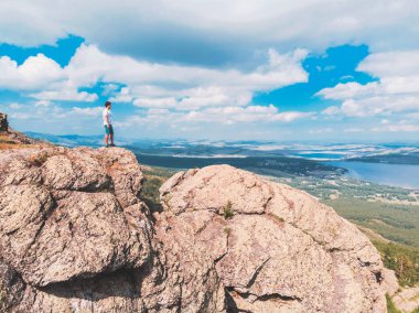 Adam bir dağ uçurumun üzerinde duruyor ve mesafe içine görünüyor. şaşırtıcı görünümü
