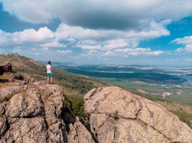 Adam bir dağ uçurumun üzerinde duruyor ve mesafe içine görünüyor. şaşırtıcı görünümü