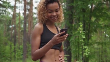 Koşu sonra Smartphone kullanarak siyah genç kadın ve yeşil ekran kameraya yavaş çekimde gösterir