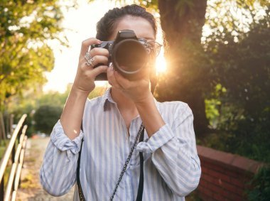 Kadın fotoğrafçı, günbatımı manzara fotoğrafını çekmek