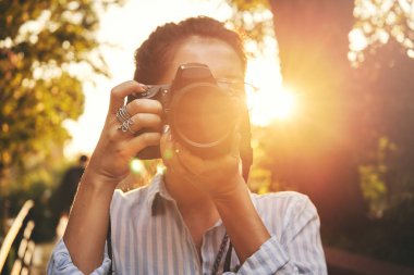 Kadın fotoğrafçı, günbatımı manzara fotoğrafını çekmek