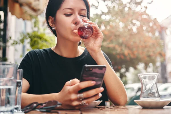 Woman drinking turkish tea from traditional turkish teacup