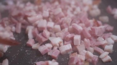 Bir aşçı ile kıyılmış pastırma sıcak bir tavada kızarmış bir tahta spatula kıpırdanırken
