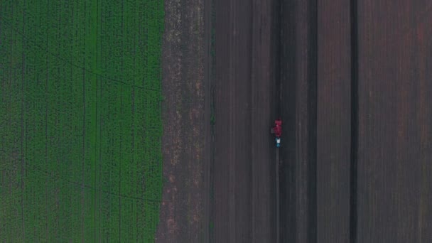 Luchtfoto van moderne aardappel-digger aanhangwagen gekoppeld aan een trekker — Stockvideo
