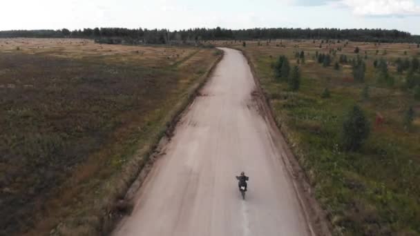 Ilmakuva, Kamera seuraa motocross ratsastaja ratsastus hänen moottoripyörä off-road radalla — kuvapankkivideo