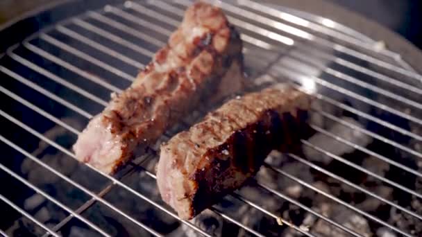 Steak vom Grill. Rippen auf dem Grill. Schweinerippchen auf Grill auf Flamme kochen — Stockvideo