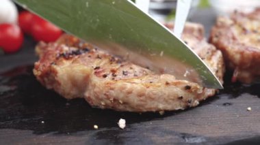 ahşap bir masa üzerinde sulu ızgara biftek kesilmiş eller